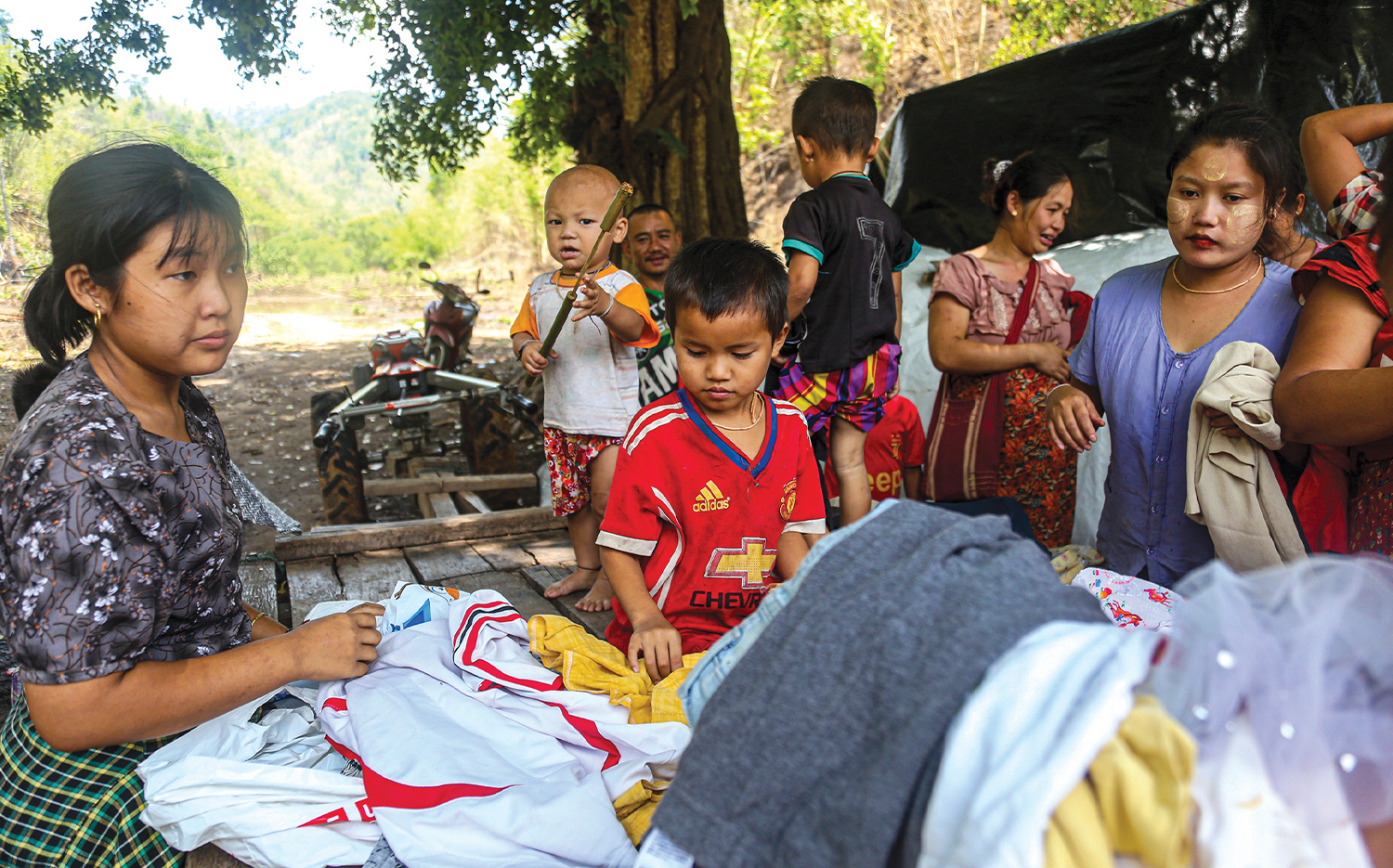 Karen refugees, who fled to the jungle, look through donated clothing.