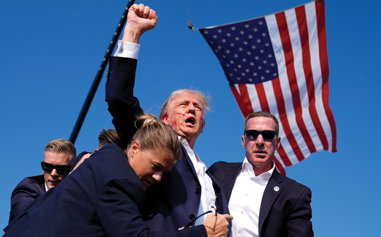 Secret Service agents surround Donald Trump after the assassination attempt at a campaign rally on July 13 in Butler, Pa.