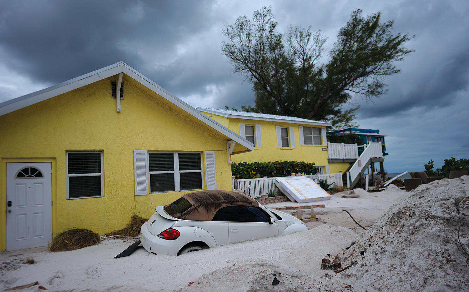 Cars and houses in Bradenton Beach, Fla., are inundated with sand after Helene’s storm surge.