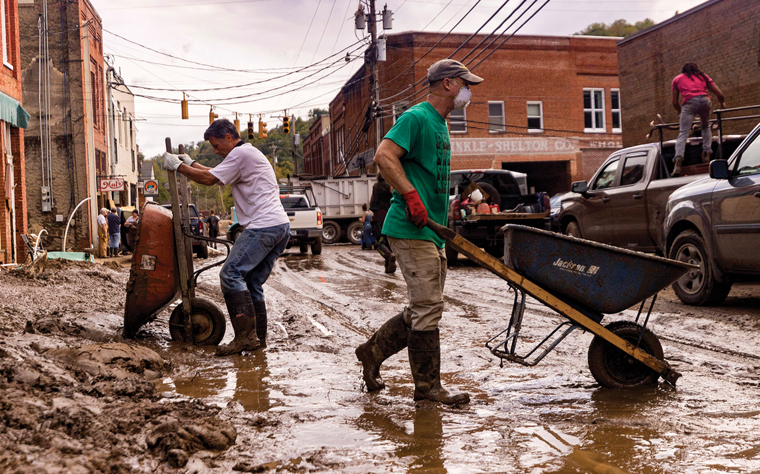 Residents and volunteers clean up after the French Broad River flooded downtown Marshall, N.C., after Helene.
