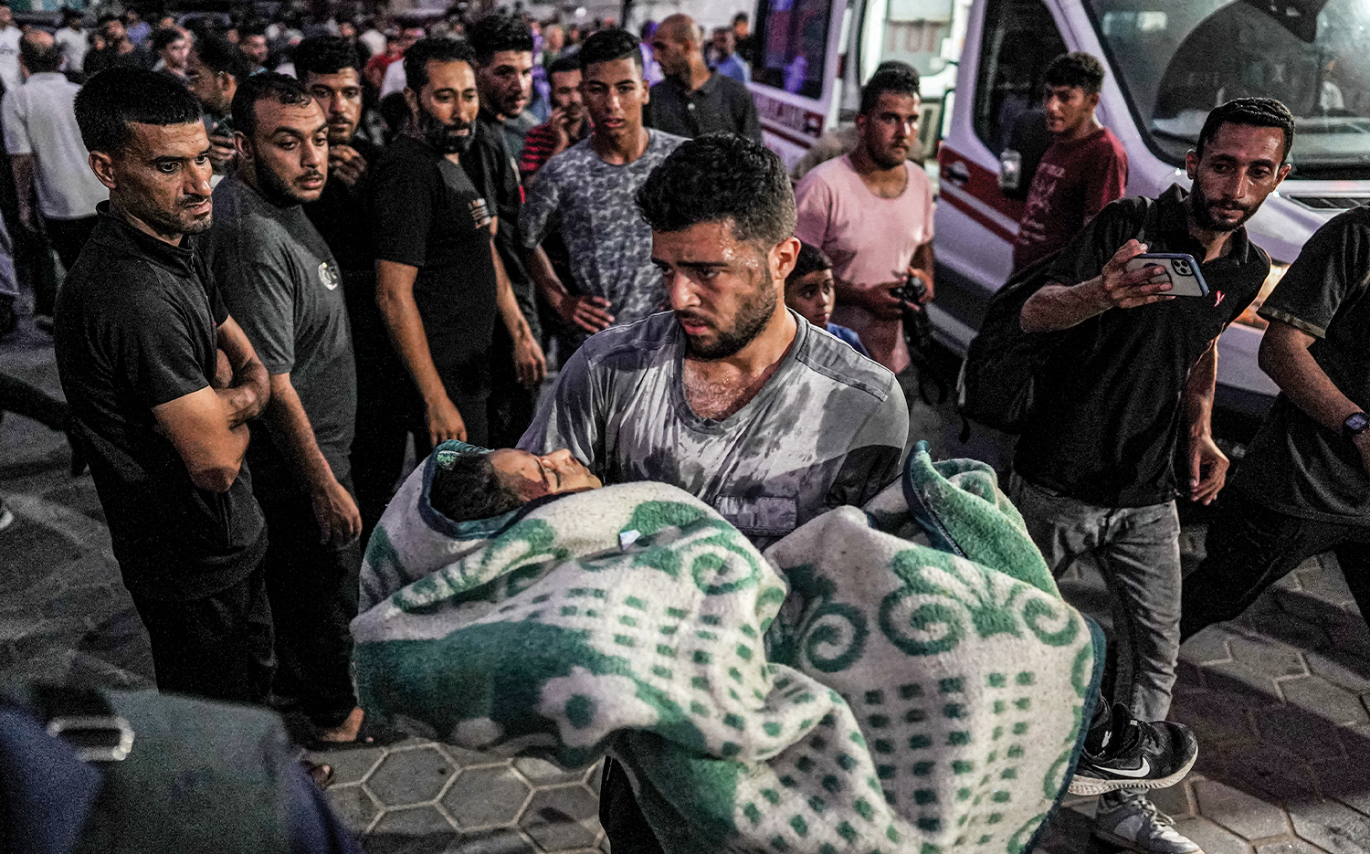A man carries a girl who was injured by Israeli bombardment in the central Gaza Strip on June 4 during the ongoing conflict between Israel and Hamas.